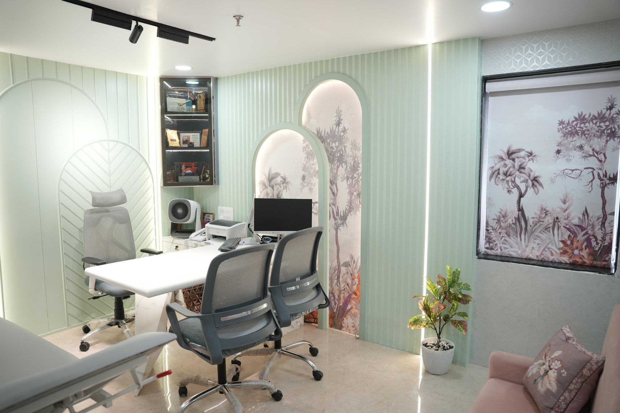 Sala de atendimento com mesa, cadeiras e computador